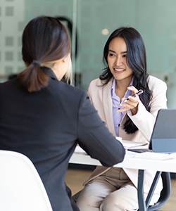 Two woman talking at a desk