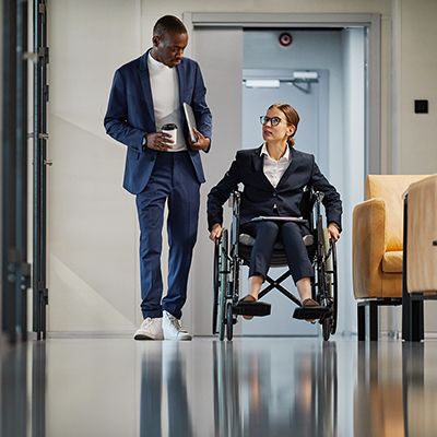 Business person talking to colleague who uses a wheelchair