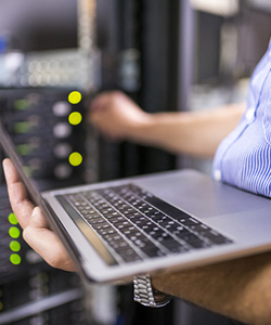 Individual working on a server holding a computer.